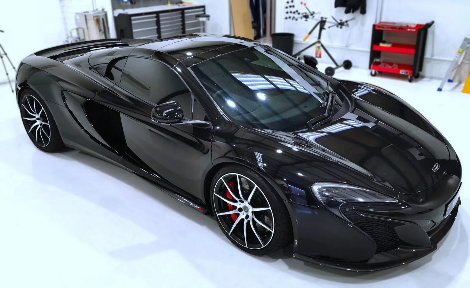 McLaren 650S receiving paint protection film on the workshop floor