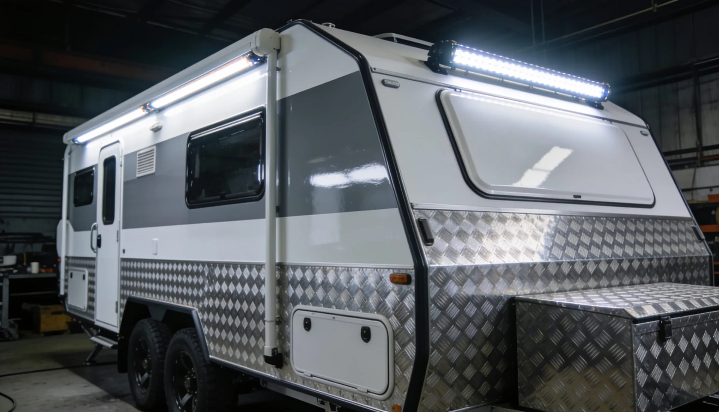 New Australian off-road caravan with checkerplate panels in a workshop bay