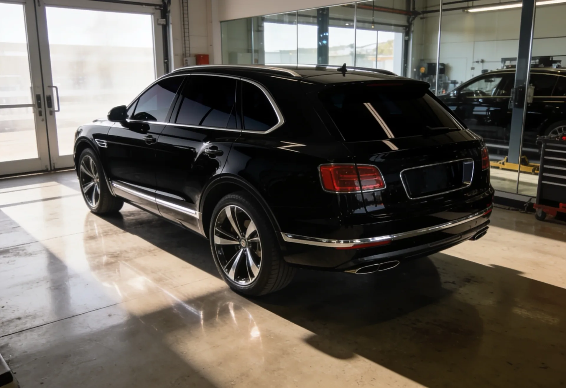 Black luxury SUV with dark ceramic window tint in the workshop